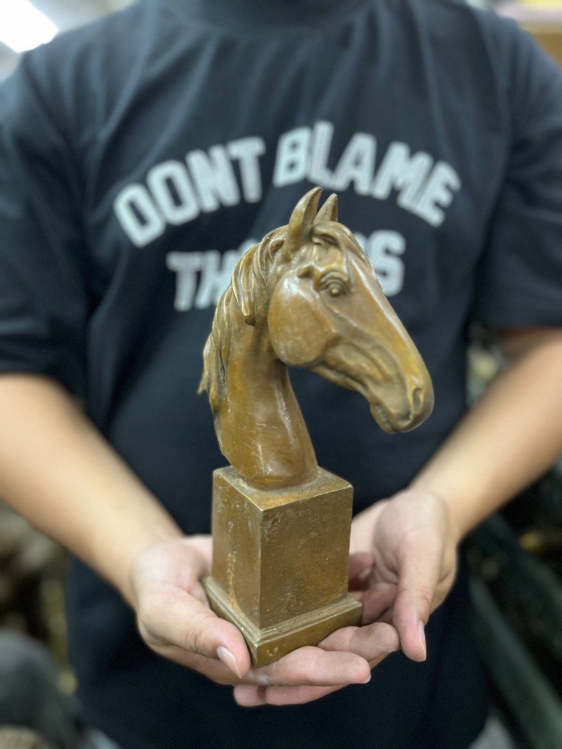 Horse Head Sculpture (Category: Other Home Decor) located in Manila. Submitted by vintage_styles_co (Listing ID 1414239232, Image 2). Description: Sculpture features a detailed horse head mounted on a rectangular base. The sculpture has a bronze-like finish. It is a decorative piece that would be a great addition to any home or office. The sculpture is held in the hands, showing its size and form..