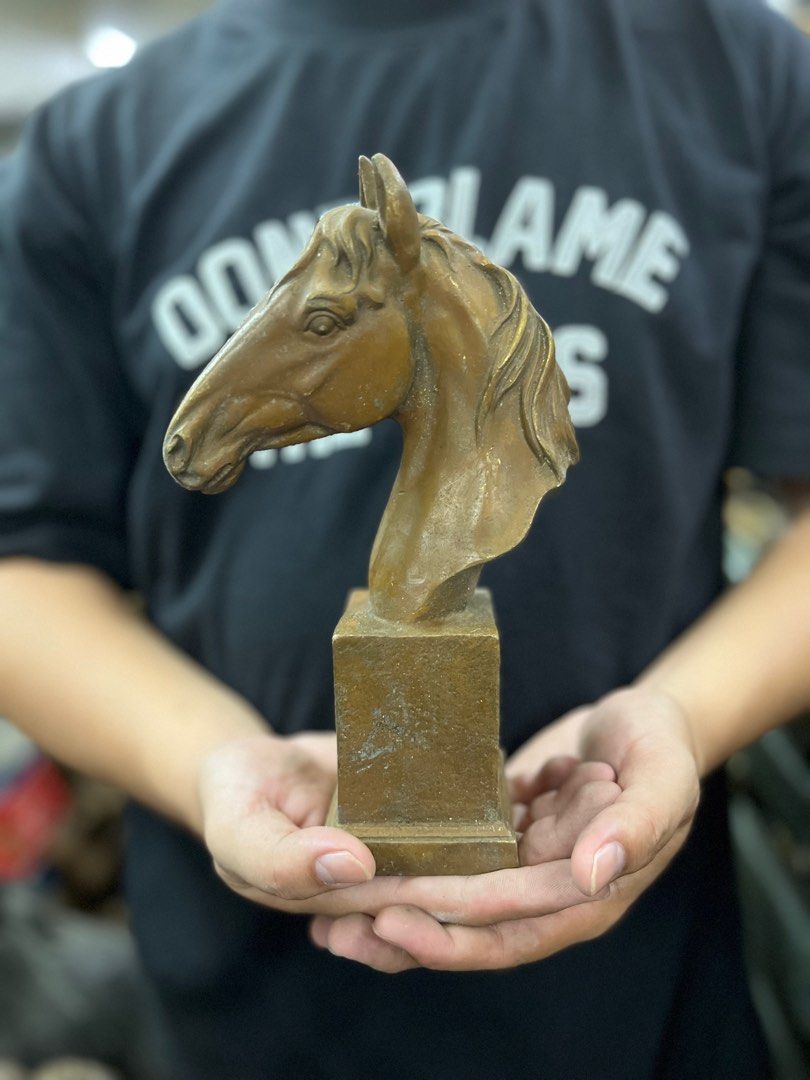 Horse Head Sculpture (Category: Other Home Decor) located in Manila. Submitted by vintage_styles_co (Listing ID 1414239232, Image 1). Description: Sculpture features a detailed horse head mounted on a rectangular base. The sculpture has a bronze-like finish. It is a decorative piece that would be a great addition to any home or office. The sculpture is held in the hands, showing its size and form..