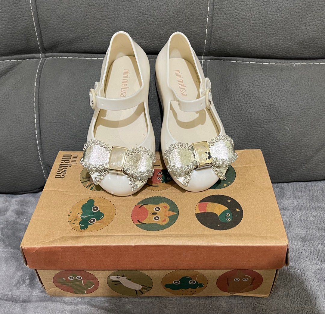 Mini Melissa - not Auth. size 9 (16cm) (Category: Babies & Kids Fashion) located in Dagupan City. Submitted by keziahiyah (Listing ID 1414211621, Image 1). Description: - Mini Melissa shoes in white - Adorned with a bow - Size 9 - Features a buckle closure - Comes with the original box - Made in Brazil - Soles show some wear.