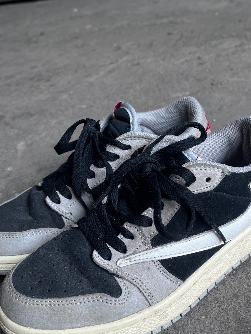 Nike Air Jordan 1 Low Travis Scott (Category: Sneakers) located in Tuguegarao City. Submitted by preloved_rx (Listing ID 1414078684, Image 1). Description: Nike Air Jordan 1 Low sneakers. Features a black, grey, and white color scheme. The shoes have black laces and the Nike Air logo is visible on the insole. The size tag indicates a size 4 for US women's. The soles show some wear. Can offer! Rfs- hindi na kasya.