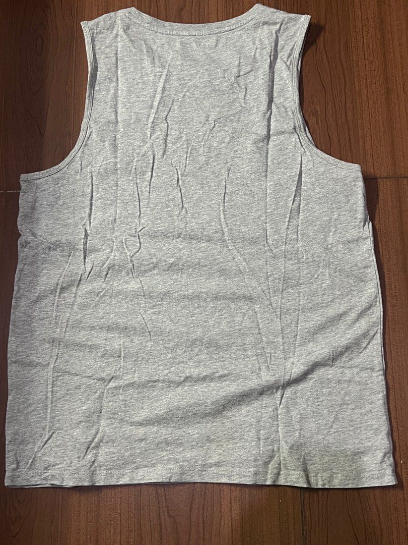 Tommy Hilfiger Grey Tank Top (Category: Activewear) located in Taguig. Submitted by matty_28 (Listing ID 1414200002, Image 2). Description: -Willing to VC for further Checking Gray tank top from Tommy Hilfiger. Features the brand's logo on the chest. The tank top has a round neckline with a red and white stripe detail. The back is plain gray. Made of a soft, cotton material..
