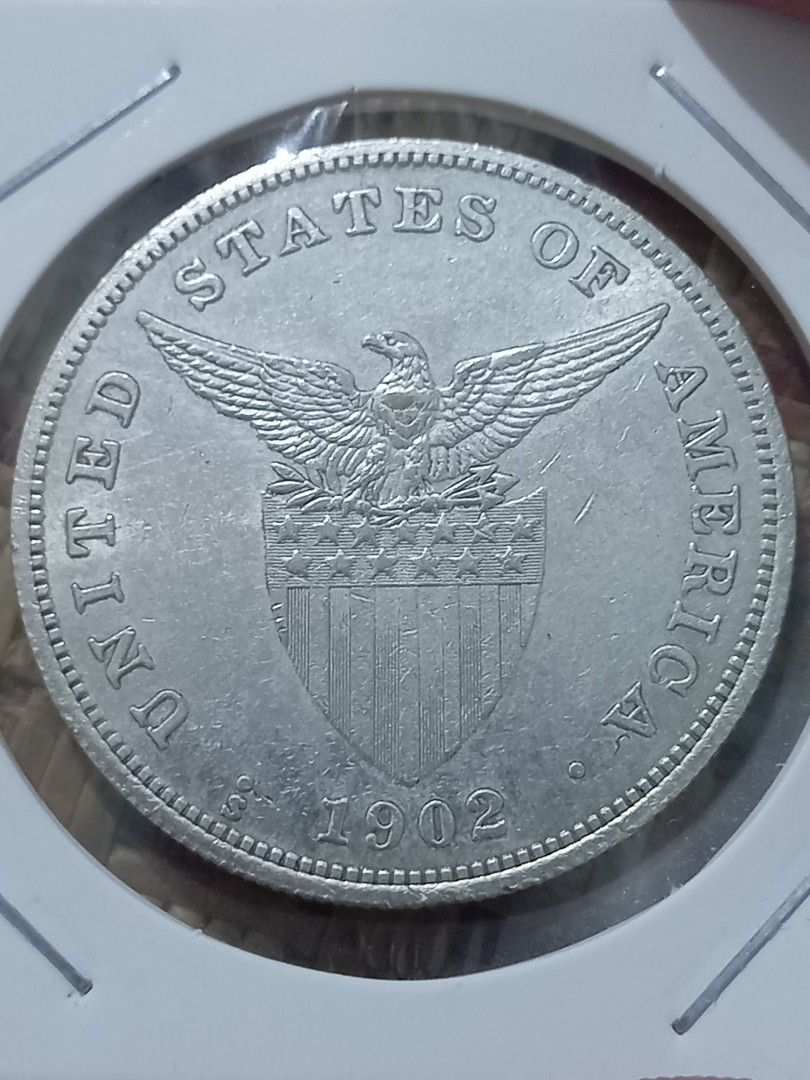 1902 US Philippines One Peso copy Coin (Category: Currency) located in Subic. Submitted by regiegabriel29 (Listing ID 1414293189, Image 1). Description: - Vintage coin from 1902. - Features "UNITED STATES OF AMERICA" on one side. - Displays "ONE PESO FILIPINAS" on the other side. - Silver in color. - Well-preserved condition..