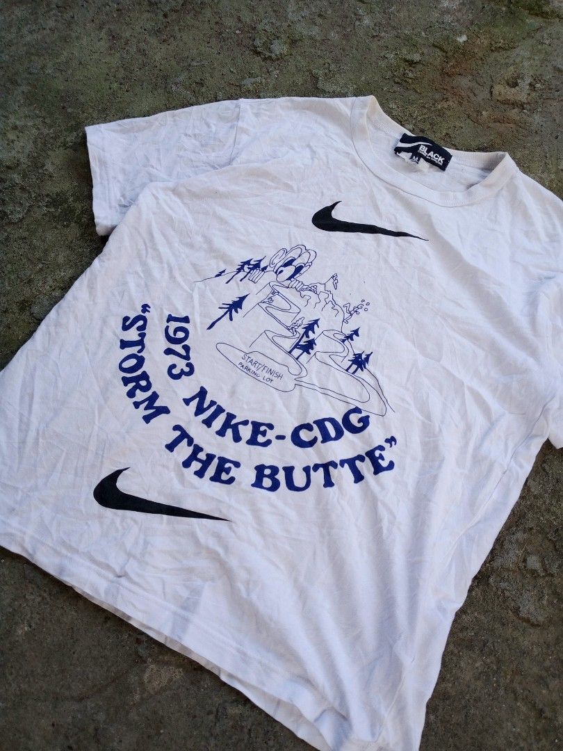 Black Comme des Garcons x Nike T-shirt (Category: Tshirts & Polo Shirts ) located in Caloocan City. Submitted by giriyeys793 (Listing ID 1414331345, Image 2). Description: - Nike x Comme des Garcons collaboration T-shirt - Features graphic print with "1973 NIKE-CDG STORM THE BUTTE" design - Size: M -Dimes 20W/26L - Made in Japan - Material: 100% cotton - Care: Hand wash recommended.