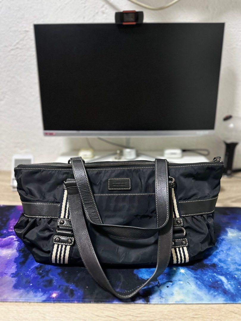 Burberry Blue Label Tote Bag (Category: Luxury Bags & Wallets) located in Angeles City. Submitted by sjd_stuff (Listing ID 1414342637, Image 2). Description: - Burberry Blue Label tote bag - Black color - Main compartment with zipper closure - Includes small interior pocket - Features a shoulder strap - Decorative stripes on the sides - Burberry logo on the front.
