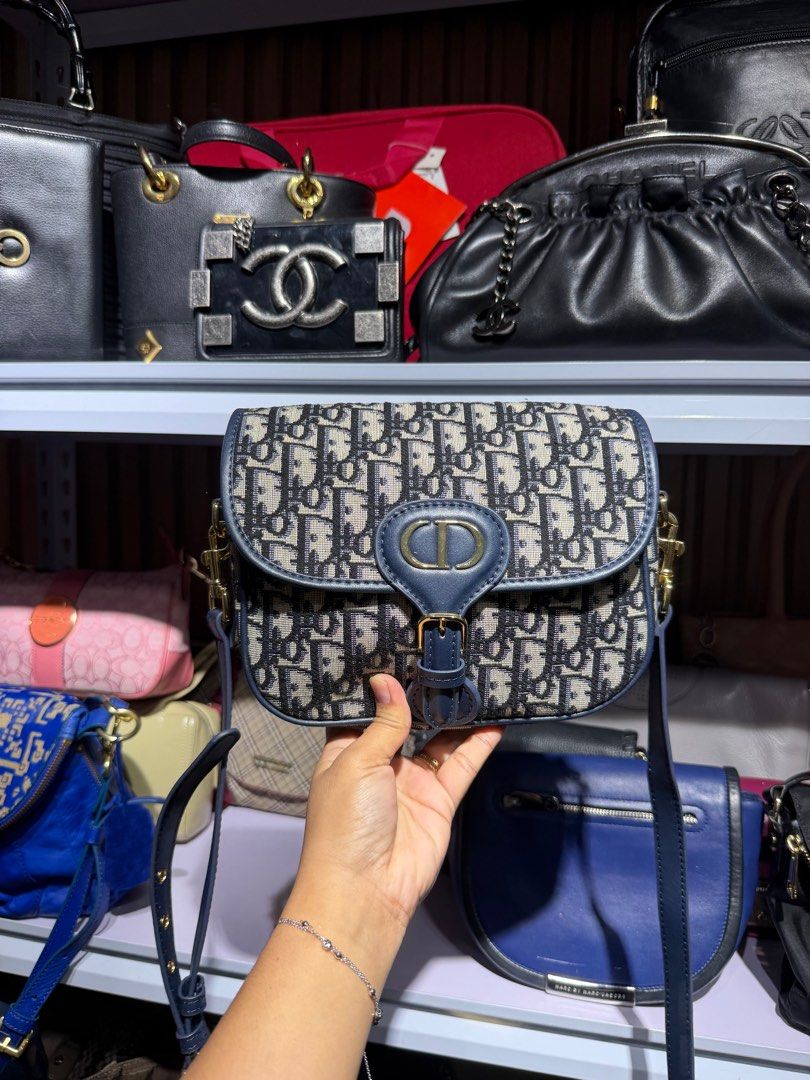 Dior Oblique Saddle Bag (Category: Luxury Bags & Wallets) located in Taguig. Submitted by xylasprelovedbag (Listing ID 1414262509, Image 1). Description: - Dior Oblique Saddle Bag - Iconic Dior monogram canvas - Navy blue leather flap - Gold-tone buckle closure - Detachable shoulder strap - Medium size.