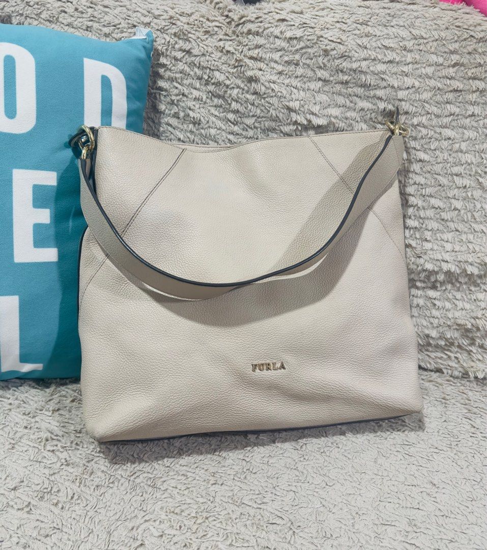 Furla Large Leather Hobo Bag (Category: Luxury Bags & Wallets) located in Manila. Submitted by vanexacast26785 (Listing ID 1407981608, Image 2). Description: - Furla Nuvola large hobo bag - Stylish and classic design - Spacious interior - Comfortable shoulder strap - Gold-tone hardware - Features Furla logo - Includes a cute plushie attached.