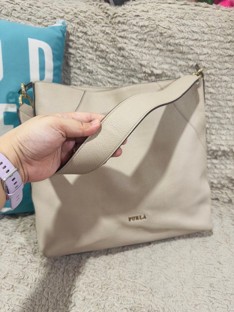 Furla Large Leather Hobo Bag (Category: Luxury Bags & Wallets) located in Manila. Submitted by vanexacast26785 (Listing ID 1407981608, Image 3). Description: - Furla Nuvola large hobo bag - Stylish and classic design - Spacious interior - Comfortable shoulder strap - Gold-tone hardware - Features Furla logo - Includes a cute plushie attached.