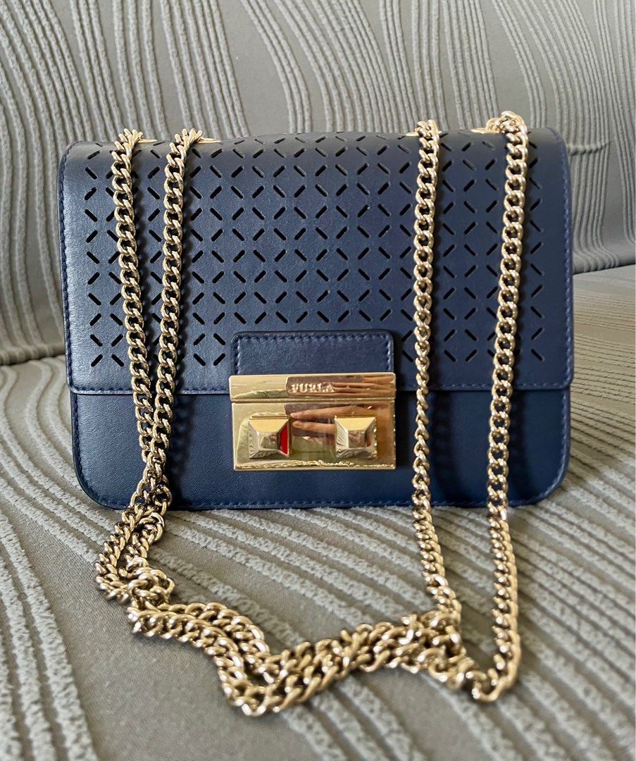 Furla Metropolis Perforated Crossbody Bag (Category: Luxury Bags & Wallets) located in Angeles City. Submitted by annedrc (Listing ID 1414264146, Image 1). Description: - Authentic Furla Metropolis crossbody bag - Navy blue leather exterior - Stylish gold chain strap and clasp (two-way) - Unique perforated design on front flap - Includes Furla label - Comes with care instructions card.