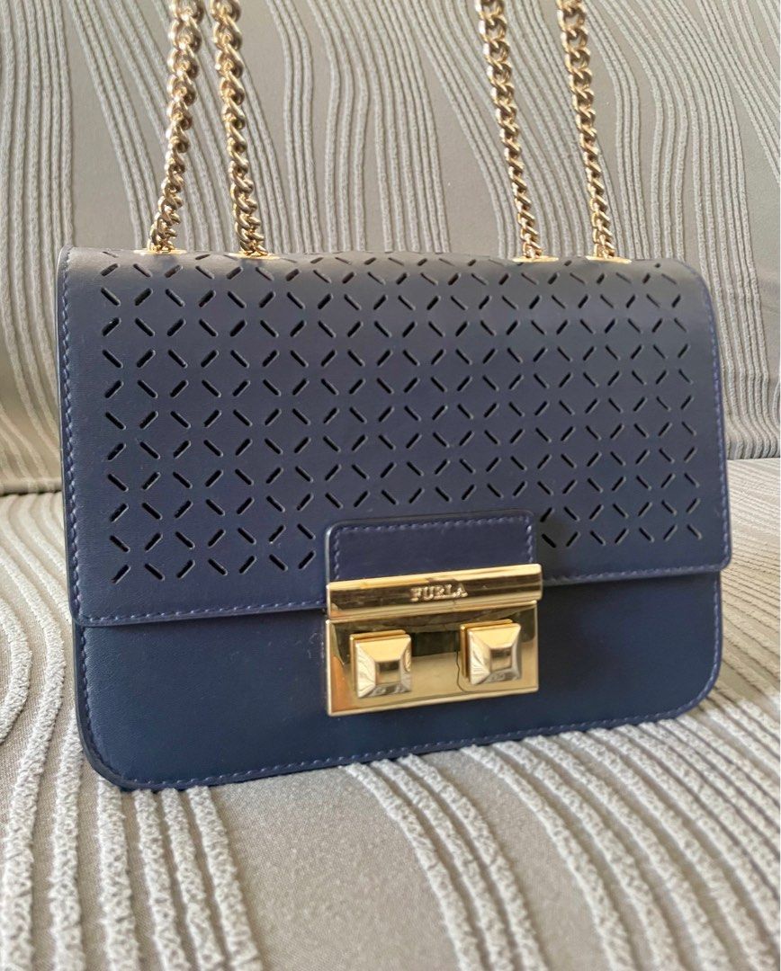 Furla Metropolis Perforated Crossbody Bag (Category: Luxury Bags & Wallets) located in Angeles City. Submitted by annedrc (Listing ID 1414264146, Image 2). Description: - Authentic Furla Metropolis crossbody bag - Navy blue leather exterior - Stylish gold chain strap and clasp (two-way) - Unique perforated design on front flap - Includes Furla label - Comes with care instructions card.