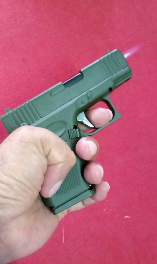 Glock 17 Austria Lighter (Category: Everything Else Others) located in Taytay. Submitted by joselaquino (Listing ID 1414251366, Image 1). Description: - Glock 17 Austria lighter - Green color - Includes a case - Pistol design - Features a trigger - Flame comes from the barrel - Includes a black attachment.