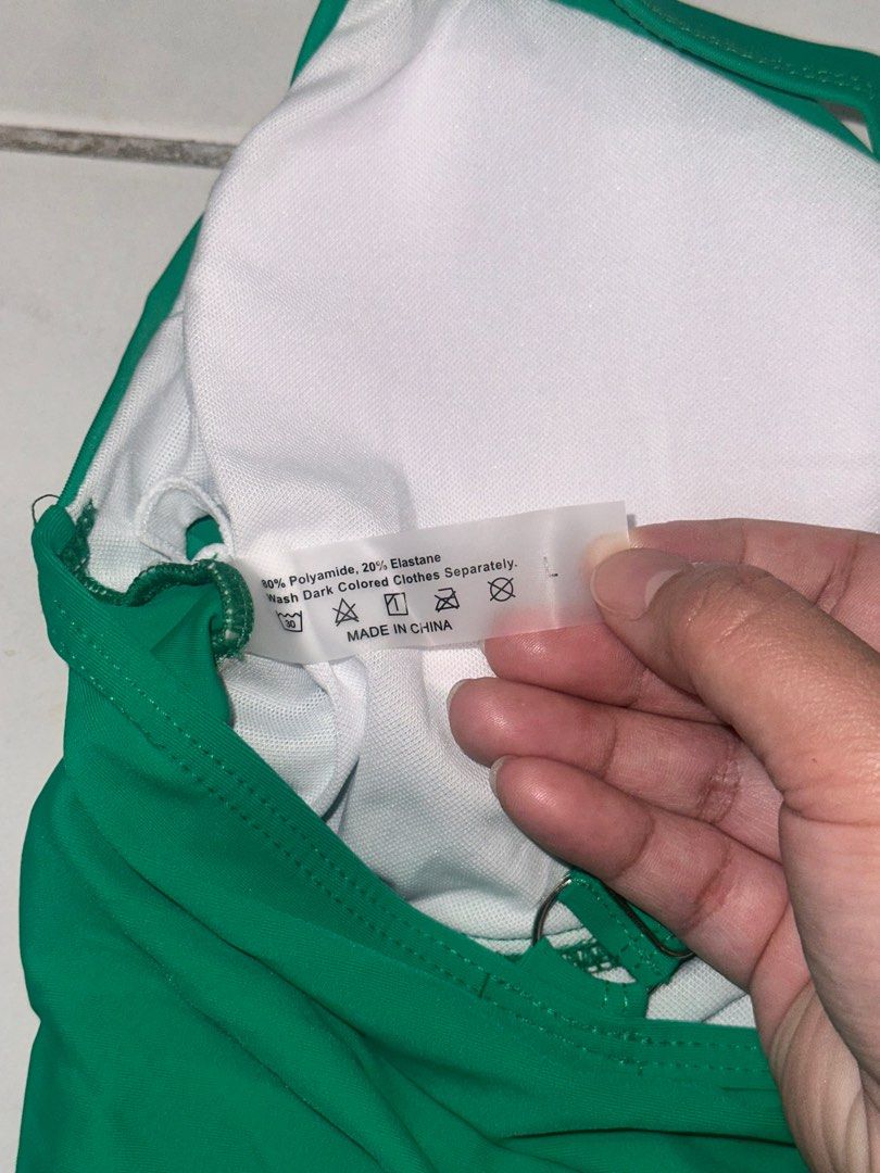 Green Halter Neck Swimsuit - Size L (Category: Bikinis & Swimsuits) located in Cavite. Submitted by iga_preloved (Listing ID 1414409308, Image 3). Description: Never been used Green one-piece swimsuit with halter neck straps. Features a knot detail at the bust. The label indicates the material is 80% Polyamide and 20% Elastane. Size L. Made in China..