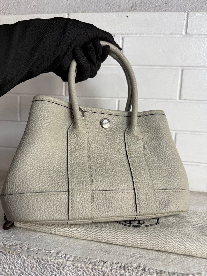 Hermes Garden Party TPM (Category: Luxury Bags & Wallets) located in Baguio. Submitted by drein30 (Listing ID 1414390339, Image 2). Description: - Hermes Garden Party handbag - Light grey exterior and interior - Structured shape - Two top handles - Snap closure - Silver-toned hardware - Interior zippered pocket - Includes dust bag.