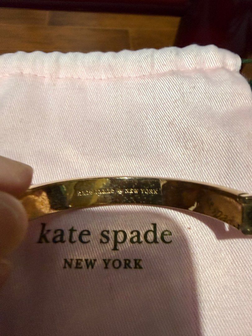 Kate Spade New York Bangle Bracelet (Category: Bracelets) located in Manila. Submitted by mjtantoco (Listing ID 1414301478, Image 2). Description: - Kate Spade New York bangle bracelet - Gold-tone finish - Brand name engraved - Includes pink dust bag - Secure clasp - Subtle design - A classic accessory.