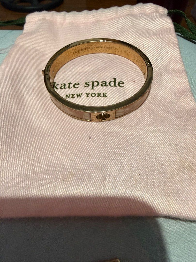 Kate Spade New York Bangle Bracelet (Category: Bracelets) located in Manila. Submitted by mjtantoco (Listing ID 1414301478, Image 1). Description: - Kate Spade New York bangle bracelet - Gold-tone finish - Brand name engraved - Includes pink dust bag - Secure clasp - Subtle design - A classic accessory.