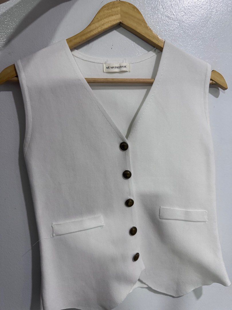 ME MAINE BASIC White Vest (Category: Sleeveless) located in Manila. Submitted by decluterthings888 (Listing ID 1414365614, Image 1). Description: - Brand: ME MAINE BASIC - Style: White vest - Features: V-neck, button closures, two front pockets - Design: Sleeveless - Material: Textured fabric - Fit: Tailored - Versatile: Perfect for layering or wearing alone.