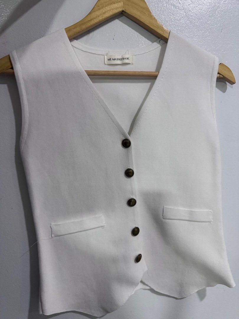 ME MAINE BASIC White Vest (Category: Sleeveless) located in Manila. Submitted by decluterthings888 (Listing ID 1414365614, Image 2). Description: - Brand: ME MAINE BASIC - Style: White vest - Features: V-neck, button closures, two front pockets - Design: Sleeveless - Material: Textured fabric - Fit: Tailored - Versatile: Perfect for layering or wearing alone.