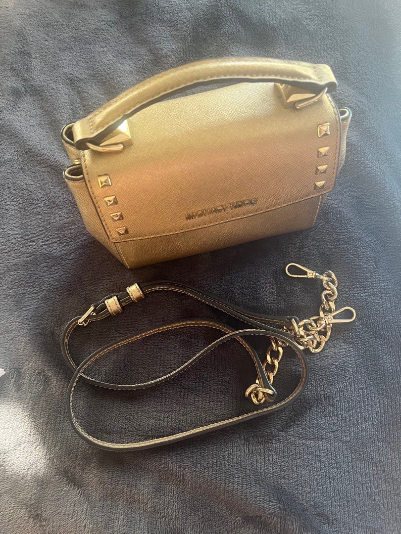 Michael Kors Gold Crossbody Bag (Category: Luxury Bags & Wallets) located in Guiguinto. Submitted by tearsayrin (Listing ID 1414314235, Image 2). Description: - Michael Kors crossbody bag in metallic gold. - Top handle and detachable chain strap. - Flap closure with studded accents. - Interior pocket. - Detachable strap for shoulder or crossbody wear..
