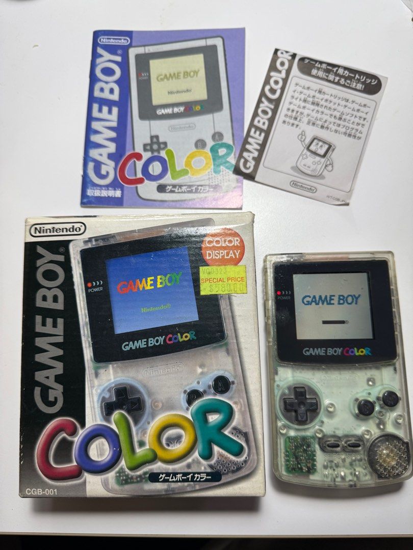 Nintendo Game Boy Color CGB-001 (Clear) (Category: Nintendo) located in Manila. Submitted by retrohere.gb (Listing ID 1414364549, Image 1). Description: - Nintendo Game Boy Color CGB-001 (Transparent) for sale. - Includes original box, instruction manual, and other paperwork. - Box features "COLOR DISPLAY" label and a special price tag. - Console powers on and displays the Game Boy logo. Price: 15,000 Php Location: Bacoor Cavite Mop: Bpi/Gcash Sh
