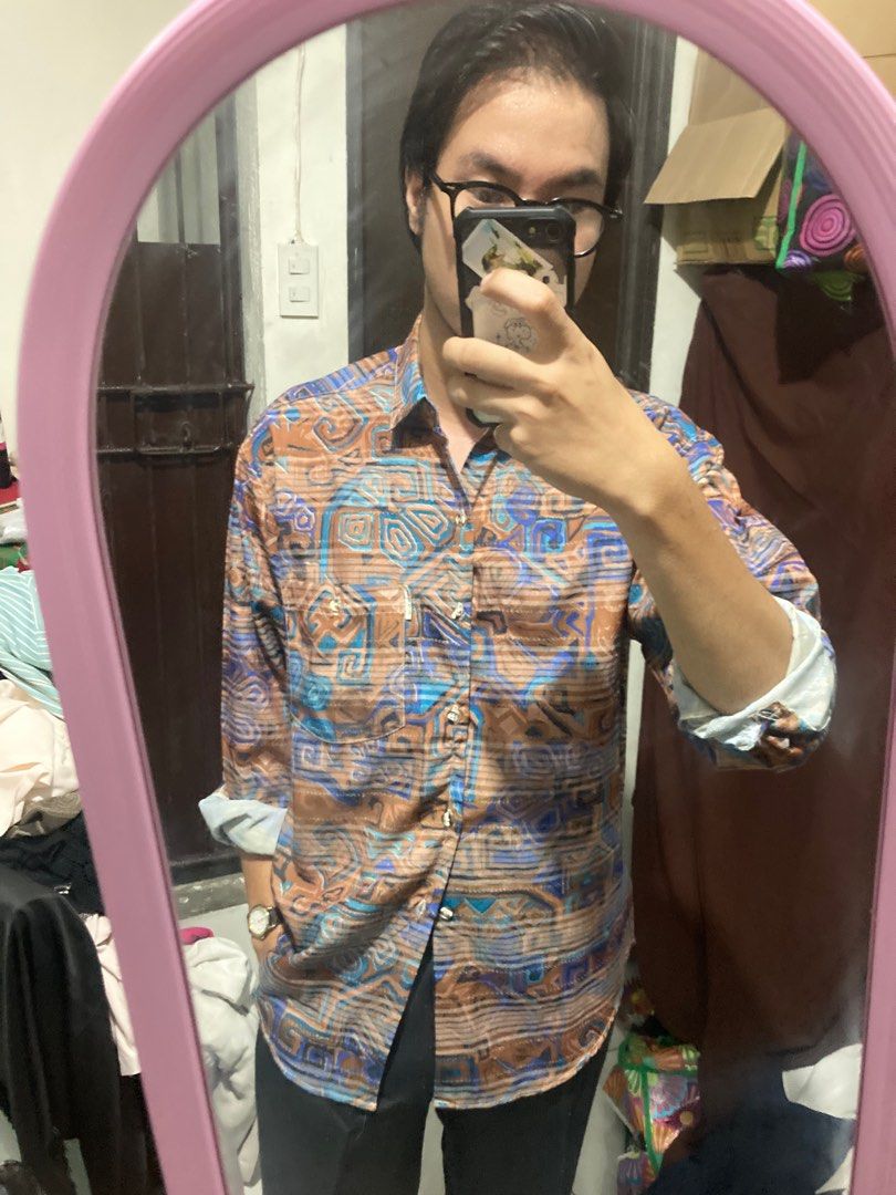 Printed Long Sleeve Shirt (Category: Tshirts & Polo Shirts ) located in Manila. Submitted by professorsinclair (Listing ID 1414333168, Image 2). Description: - Long-sleeved shirt - Unique printed design - Collared neckline - Button-down closure - Roll-up sleeves - Vibrant blue, brown, and orange pattern - Lightweight material - Suitable for various occasions.