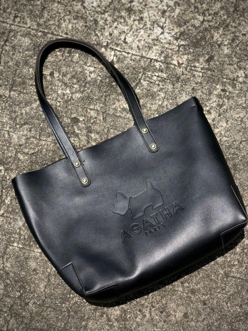 Agatha Paris Black Tote Bag (Category: Tote Bags) located in Bulacan. Submitted by koolstuffs_29 (Listing ID 1414494181, Image 2). Description: - Agatha Paris tote bag - Black color - Features iconic dog logo and brand name - Gold-colored rivet details - Made of smooth, possibly leather-like material - Rectangular shape with structured base.