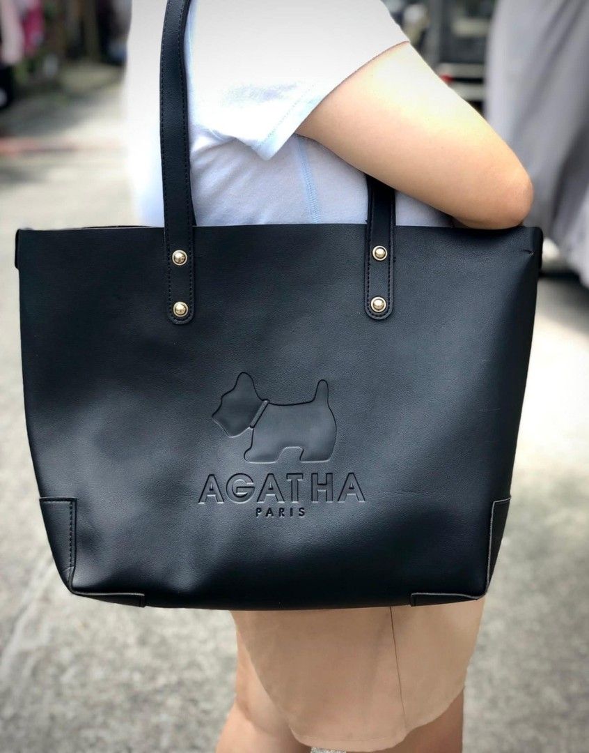 Agatha Paris Black Tote Bag (Category: Tote Bags) located in Bulacan. Submitted by koolstuffs_29 (Listing ID 1414494181, Image 1). Description: - Agatha Paris tote bag - Black color - Features iconic dog logo and brand name - Gold-colored rivet details - Made of smooth, possibly leather-like material - Rectangular shape with structured base.