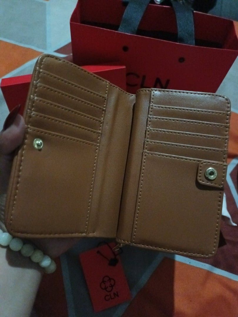 CLN EMELIE Wallet (Category: Wallets & Card holders) located in Caloocan City. Submitted by gadayanbryanken24-38131 (Listing ID 1414533586, Image 3). Description: - CLN EMELIE WALLET - Brown and patterned design - Multiple card slots - Zippered compartment - Snap closure - Includes original box, dust bag, and tags - Unused condition.