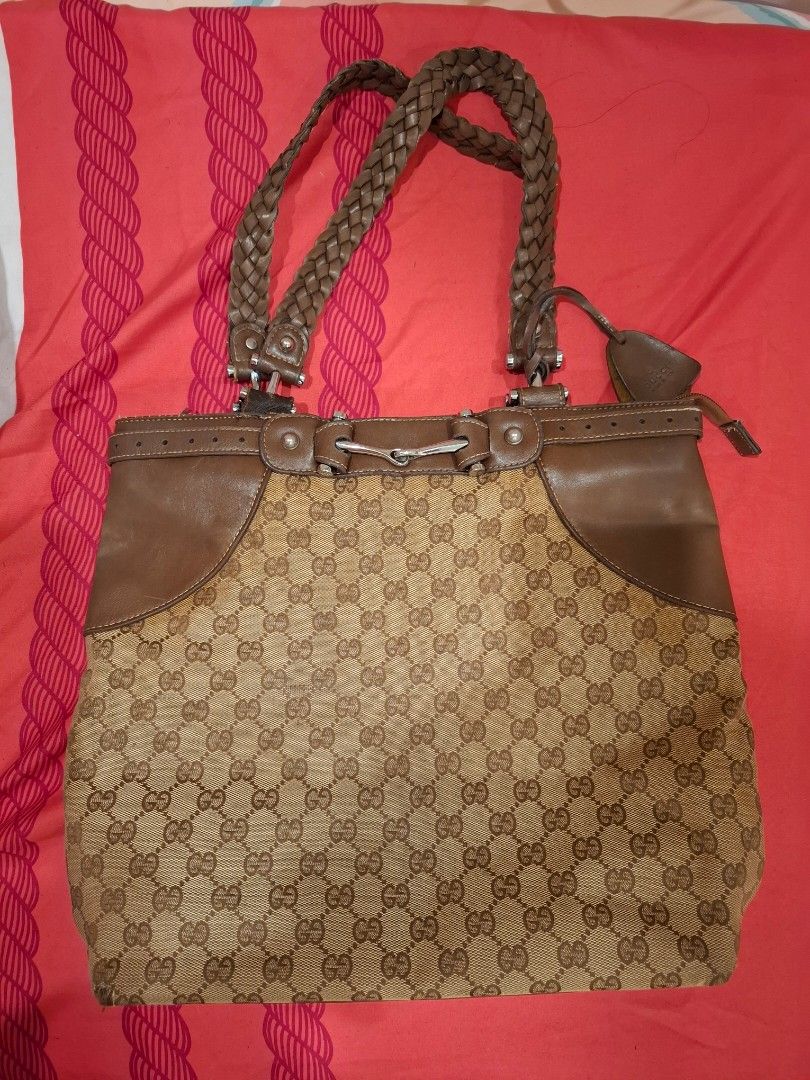 Gucci GG Canvas Tote Bag (Category: Luxury Bags & Wallets) located in Manila. Submitted by warmcat-ee9368 (Listing ID 1414579303, Image 1). Description: - Authentic Gucci tote bag - Iconic GG canvas pattern - Brown leather accents - Braided handle - Light brown fabric lining - Includes Gucci leather tag - Made in Italy - Minor wear on one corner.