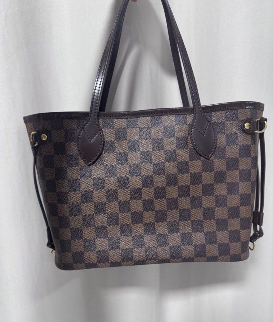 Louis Vuitton Damier Ebene Tote Bag PM (Category: Luxury Bags & Wallets) located in Manila. Submitted by decluterthings888 (Listing ID 1414604912, Image 1). Description: - Authentic Louis Vuitton tote bag NEVERFULL PM - Iconic Damier Ebene pattern - Structured shape - Brown leather handles and trim - Gold-tone hardware - Includes side straps.