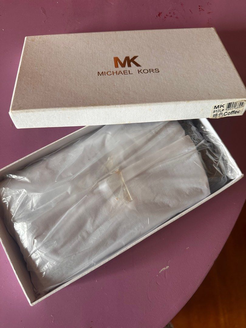 Michael Kors Zip Around Wallet (Class A) (Category: Wallets & Card holders) located in Tanza. Submitted by euniceericka (Listing ID 1414467296, Image 3). Description: - Authentic Michael Kors zip-around wallet (Class A) - Brown with iconic MK logo print - Multiple card slots - Zippered compartment - Gold-tone zipper and hardware - Interior: Orange - Includes original box - Signature detail on front - Never been used RFS: Decluttering .