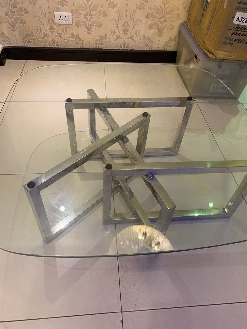 Modern Glass Coffee Table with Stainless Steel Frame (Category: Tables & Sets) located in Paranaque City. Submitted by trudetam (Listing ID 1414606942, Image 2). Description: - Stylish coffee table - Clear glass top - Unique stainless steel frame - Rectangular shape with rounded corners - Modern design - Great for living rooms.