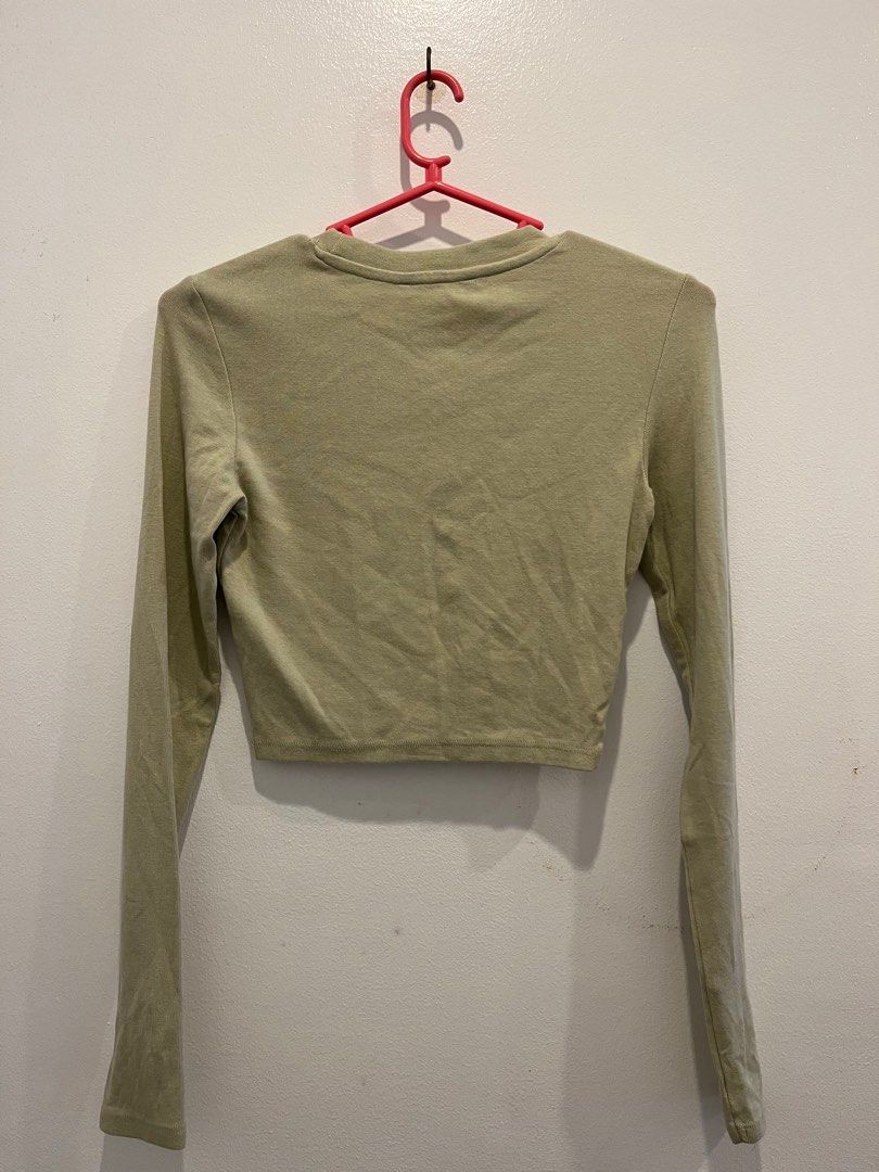Olive Green Long Sleeve Cropped Top (Category: Longsleeves) located in Antipolo. Submitted by _gellavctrn (Listing ID 1414486117, Image 2). Description: - Olive green long sleeve cropped top - Soft, lightweight fabric with comfortable stretch - Classic crew neckline - Fitted silhouette, great for layering or casual wear - Cropped length pairs well with high-waisted jeans or skirts - Pre-owned condition - Ripped tag (not visible) - No holes or maj