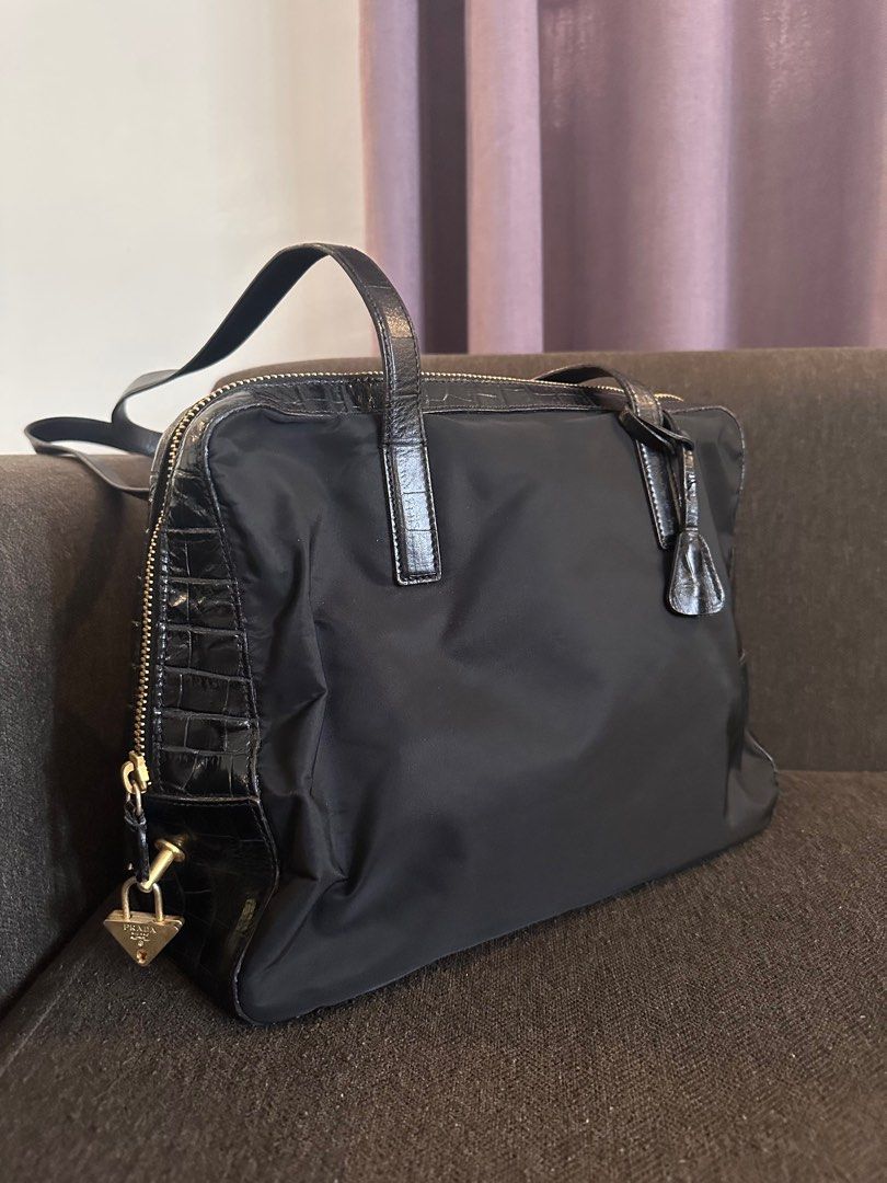 Prada Black Crocodile Leather Shoulderbag (Category: Luxury Bags & Wallets) located in Batangas. Submitted by kulilayfinds (Listing ID 1414483393, Image 3). Description: Black Prada handbag with crocodile leather accents. Features a gold zipper and a Prada logo on the front. Includes a detachable lock with the Prada logo. The interior has a Prada logo lining and a small zippered pocket. The handle shows some wear. Made in Italy. Missing puller ta