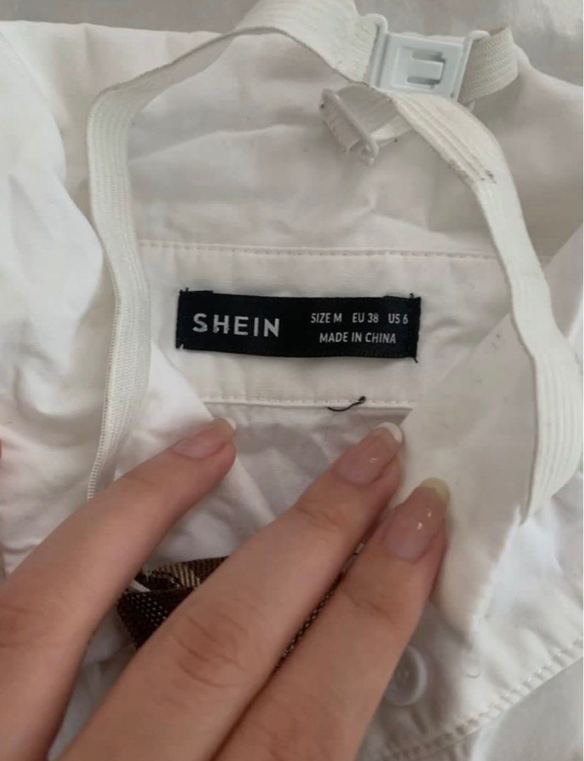 Shein White Shirt with Tie (Category: Shirts) located in Manila. Submitted by geecobra (Listing ID 1414519538, Image 3). Description: - Shein white cropped shirt - Includes a matching brown plaid tie - Size: M (EU 38, US 6) - Features button closures - Short sleeves with gathered shoulder detail - Comes with a collar - Versatile tie included.