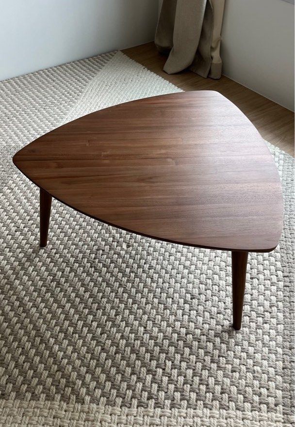 Triangular Solid Teak Coffee Table (Category: Tables & Sets) located in Singapore. Submitted by konicashoes (Listing ID 1414562257, Image 3). Description: Karpenter Vintage Tripod Teak Coffee Table An elegant designer coffee table by Karpenter, showcasing a distinctive triangular tripod silhouette. Expertly crafted from solid teak wood, the table features a rich, warm finish that highlights the natural grain and timeless beauty of the material. T
