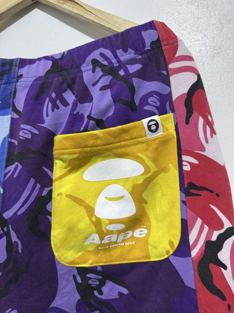 Aape By A Bathing Ape Camo Shorts (Category: Shorts) located in Manila. Submitted by esparciake75752 (Listing ID 1465280584, Image 3). Description: Multicolor camo shorts from Aape by A Bathing Ape. Features patchwork design in blue, purple, pink, and grey camo patterns. Branded drawstring waist, rubber ape logo patch on front leg, yellow back pocket with white ape head print. Statement streetwear piece, relaxed fit, premium cotton fleece materia