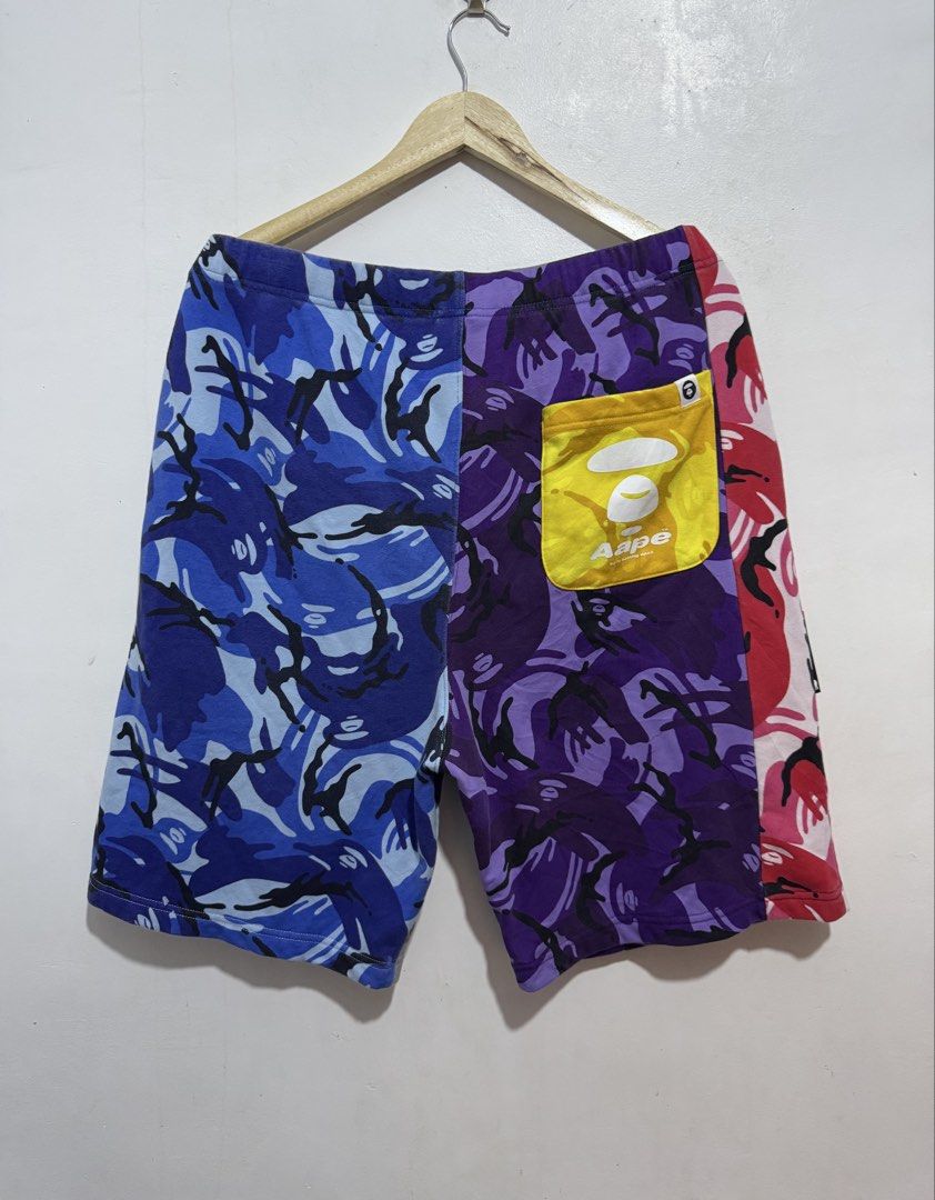 Aape By A Bathing Ape Camo Shorts (Category: Shorts) located in Manila. Submitted by esparciake75752 (Listing ID 1465280584, Image 2). Description: Multicolor camo shorts from Aape by A Bathing Ape. Features patchwork design in blue, purple, pink, and grey camo patterns. Branded drawstring waist, rubber ape logo patch on front leg, yellow back pocket with white ape head print. Statement streetwear piece, relaxed fit, premium cotton fleece materia
