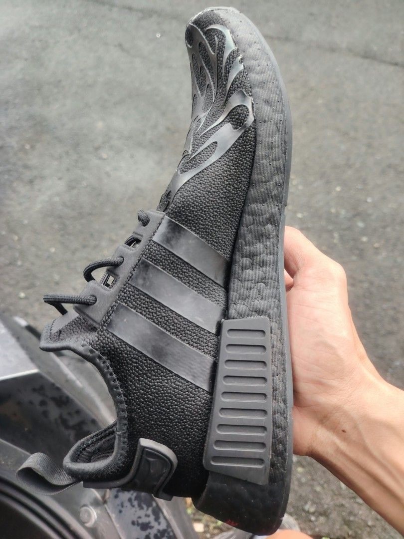 Adidas NMD R1 Black Sneakers (Category: Casual Shoes) located in Manila. Submitted by ms.thightangbudget (Listing ID 1465298652, Image 2). Description: - Model: Adidas NMD R1 (All Black) - Design: Mesh upper with reflective flame graphics near the toe and matching black three stripes - Comfort: Responsive Boost midsole and black EVA plugs - Details: Heel pull tab attached, very clean soles - Condition: Ready to wear - Versatility: Perfect for cas