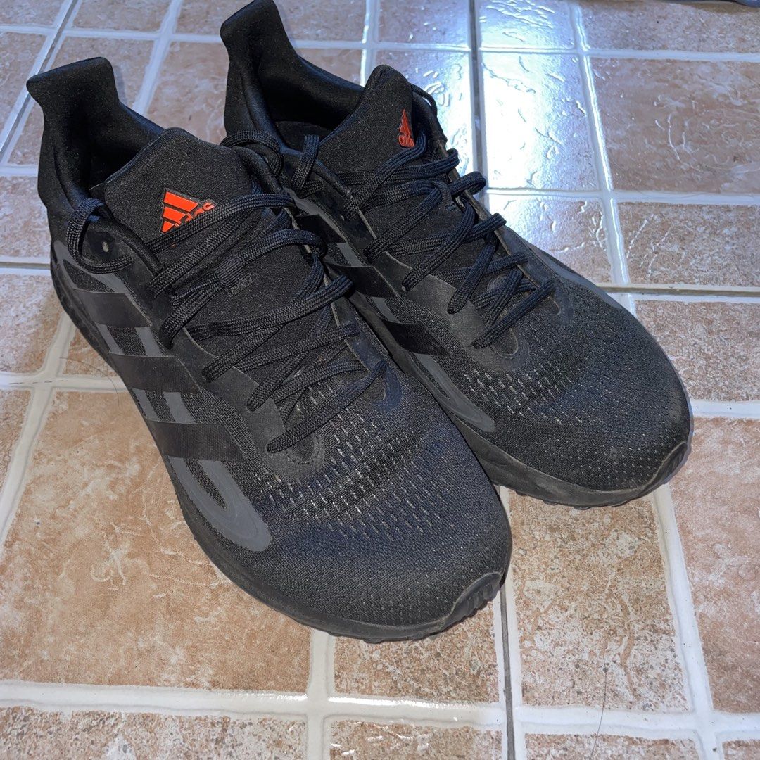 Adidas SolarGlide Black Night Metallic (Category: Sneakers) located in Valenzuela. Submitted by redanselmo (Listing ID 1465327973, Image 2). Description: - Brand: Adidas Solarglide - Color: Black with vibrant orange accents on the tongue and heel tab - Cushioning: Responsive Boost midsole for maximum comfort - Size: US 9.5 | UK 9 | FR 43 1/3 - Condition: Normal wear on soles and uppers from previous use - Perfect for daily runs or casual wear - S