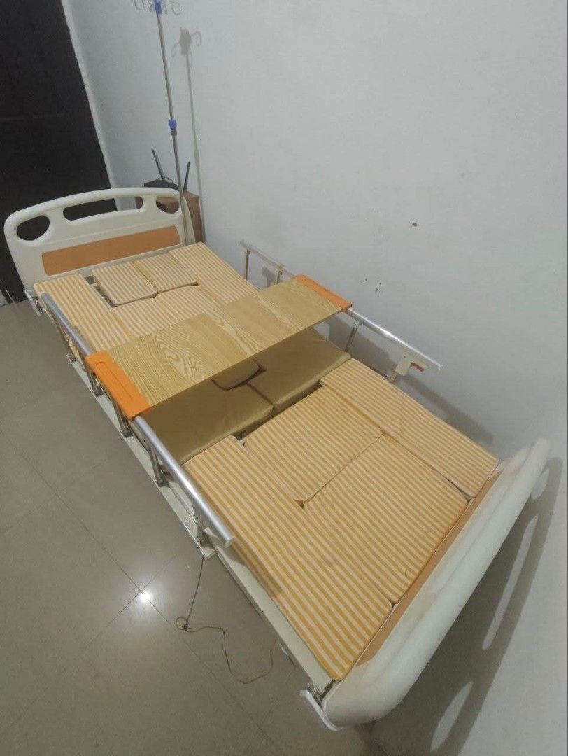 Adjustable Medical Hospital Bed with Dining Tray (Category: Medical Supplies & Tools) located in Mandaluyong City. Submitted by quickmountain.780662 (Listing ID 1465173623, Image 1). Description: - Adjustable medical bed ideal for home care needs - Includes comfortable striped cushions - Removable wooden dining tray that goes across the middle - Built-in metal IV pole for convenience - Side safety rails with stylish white and orange headboard and