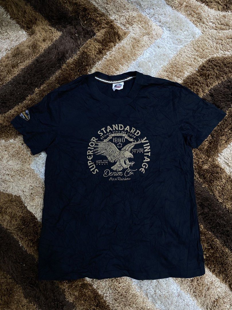 Air & Rainbow Black Graphic T-Shirt (Category: Tshirts & Polo Shirts ) located in Butuan. Submitted by nielben13 (Listing ID 1465200247, Image 1). Description: - Brand: Air & Rainbow - Color: Black - Material: 100% Premium Cotton - Design: Large eagle graphic with 'Superior Standard Vintage Denim Co.' lettering on the front - Details: Small matching patch on the right sleeve, crew neck with stylish striped inner taping - Condition: Excellent / We