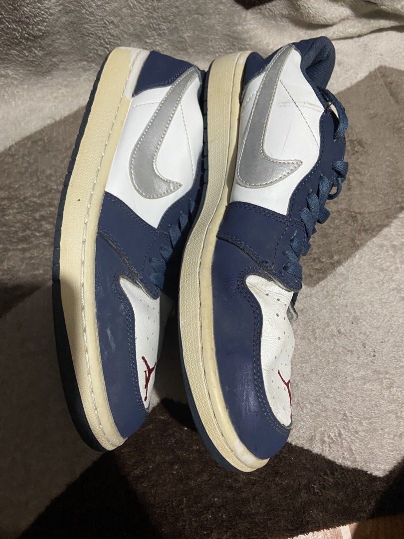 Air Jordan 1 Low Midnight Navy Silver (Category: Sneakers) located in Manila. Submitted by kiyanna.preloved (Listing ID 1465362036, Image 2). Description: - Model: Navy blue and white leather low-top sneakers - Accents: Silver swoosh, red embroidered Jumpman on toe box, white embroidered wings logo on heel - Details: Dark blue laces and matching outsoles - Condition: Regular wear, features noticeable creasing on the leather upper and yellowing on