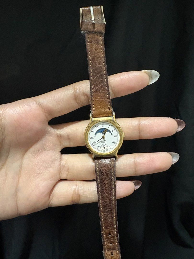Moonphase Watch Seiko Alba (Category: Men's Watches) located in Caloocan City. Submitted by esnairahhh (Listing ID 1465378107, Image 1). Description: - Brand: Vintage Alba - Movement: Reliable quartz - Display: White dial with Roman numerals, moonphase at 12 o'clock, and small seconds sub-dial - Aesthetics: Gold-tone case and bezel - Condition: Shows visible wear, including cracking on the brown leather strap and fading/tarnishing on the gold pla