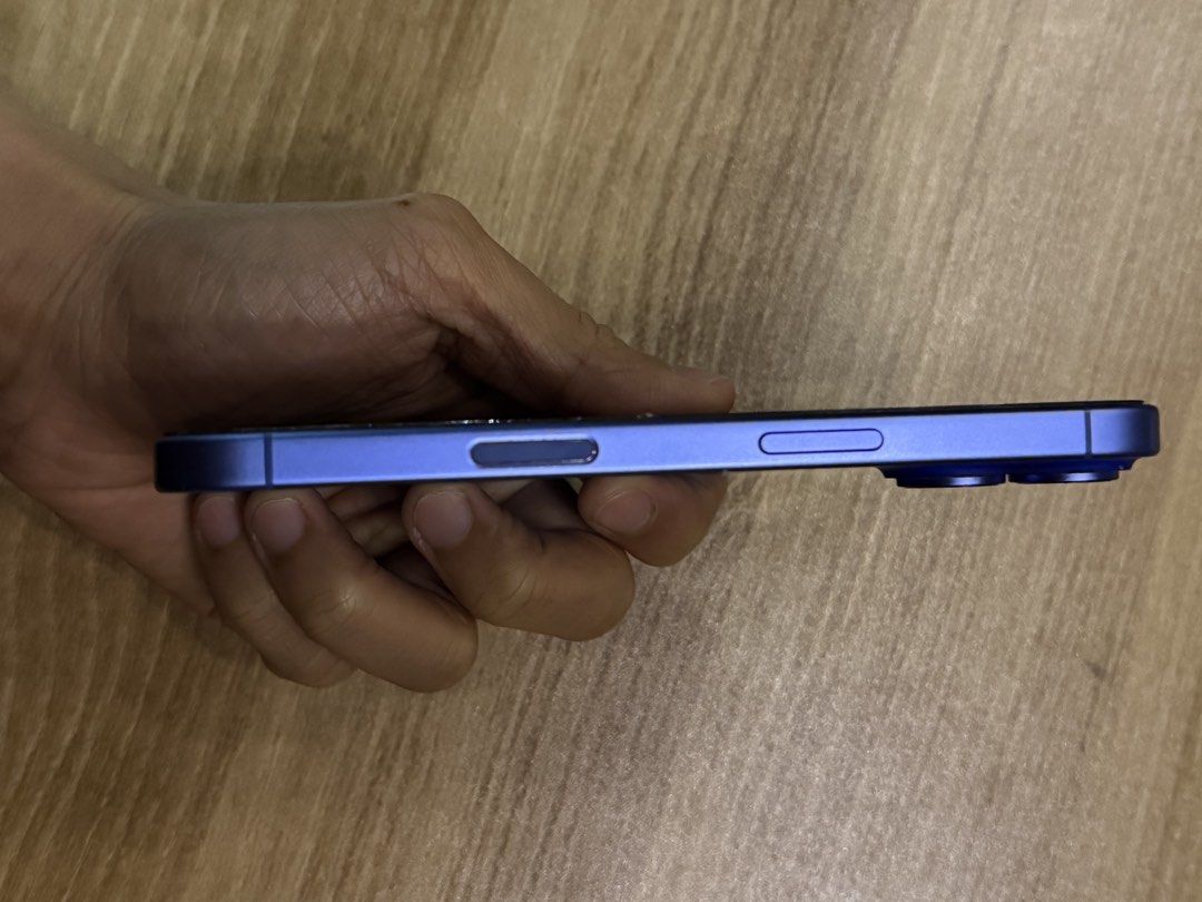 Apple iPhone (Category: iPhone 16 Series) located in Quezon City. Submitted by ags.studio (Listing ID 1465281321, Image 3). Description: - Model: Ultramarine-colored iPhone with dual-camera setup (with box) - Screen: Glass screen protector installed (minor wear on edges of the screen protector) - Features: Physical SIM tray slot and responsive side buttons - Fulfillment: Available for shipping or buyer meetup - Issue/s: Green screen issue during 