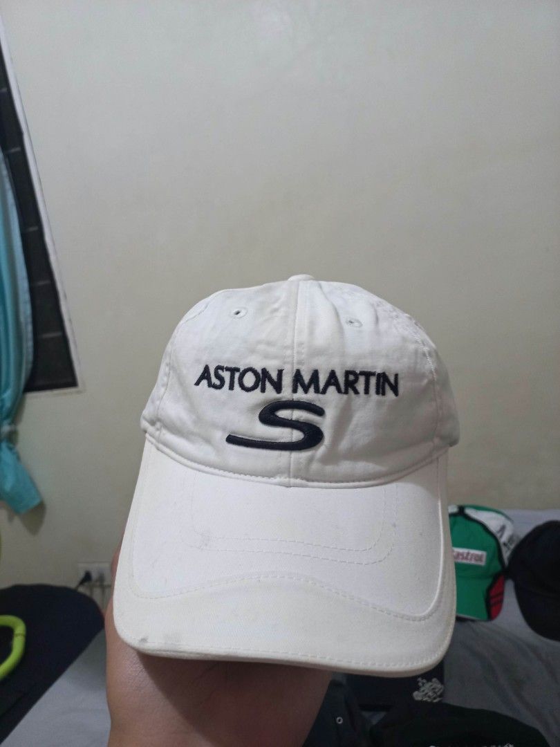 Aston Martin S White Baseball Cap (Category: Caps & Hats) located in Davao. Submitted by thegraildept2026 (Listing ID 1465178707, Image 1). Description: - Authentic white Aston Martin baseball cap - Detailed embroidered logo on front and back with the letter S - Adjustable strap with a metal buckle for a custom fit - Features interior tag stitched inside - Condition: Minor signs of wear and slight discoloration around the brim.