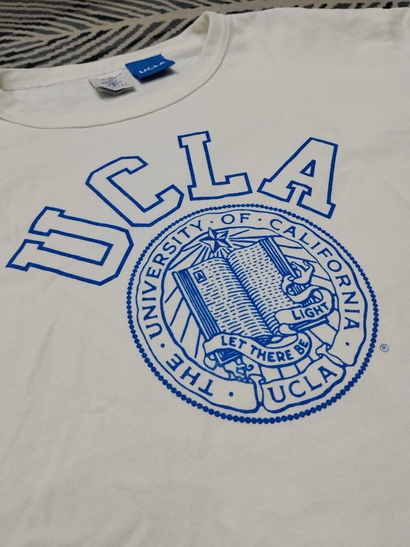 Authentic Champion T1011 UCLA Heavyweight Jersey (Category: Tshirts & Polo Shirts ) located in Manila. Submitted by titokingcuratedarchive (Listing ID 1465203280, Image 2). Description: - Brand/Model: Champion T1011 UCLA Heavyweight Jersey T-Shirt - Color: White with classic blue UCLA collegiate front graphic - Size: Large - Origin: Made in USA - Material: Premium thick cotton fabric for maximum durability - Details: Iconic Champion C-logo patch 