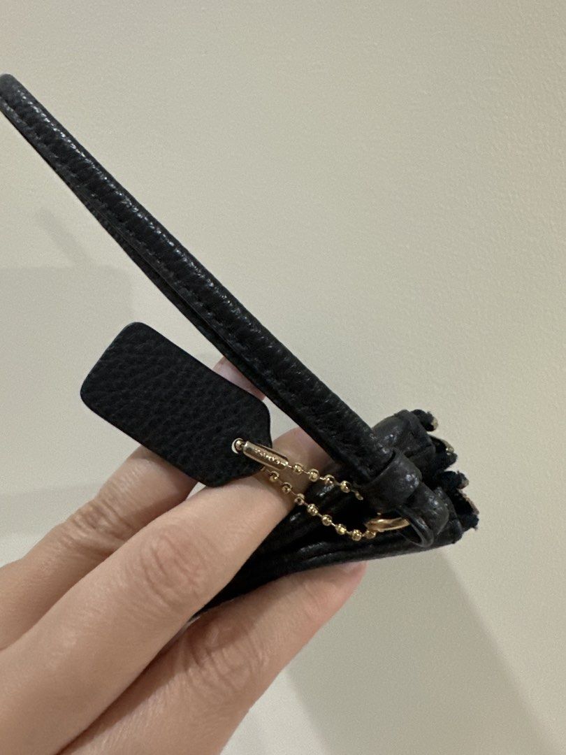 Authentic Coach Black Leather Handbag with Hangtag (Category: Luxury Bags & Wallets) located in Manila. Submitted by pinkrainbowph (Listing ID 1465314065, Image 1). Description: - Authentic Coach bag in classic black pebbled leather - Features matching black leather hangtag on a gold-tone ball chain - Secured with a slim strap and durable metal hardware - Compact size ideal for quick errands or night outs - Condition: Minimal wear on the strap an