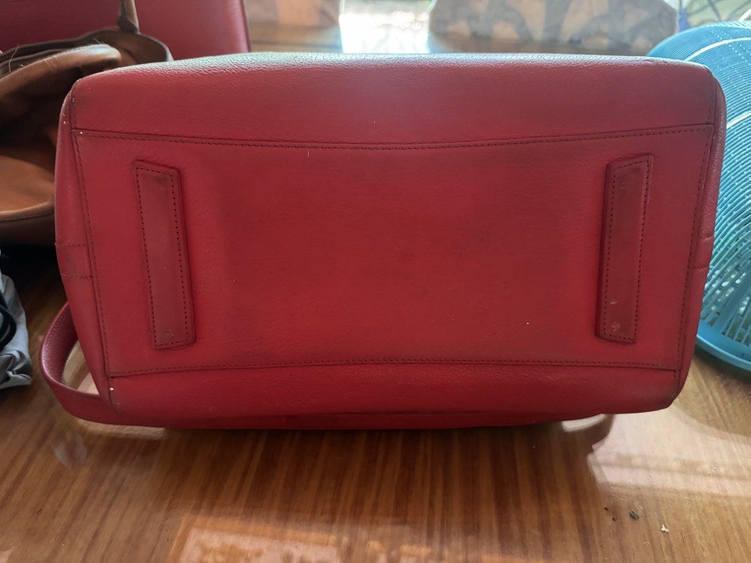 Authentic Givenchy Red Leather Handbag with Twilly Scarf (Category: Luxury Bags & Wallets) located in Taguig. Submitted by mhay.molina (Listing ID 1465268055, Image 3). Description: - Brand: Givenchy - Color: Bright red with silver-tone hardware - Material: Premium leather with beige fabric interior - Design: Structured trapezoid shape with embossed logo and protective feet - Handles: Double top handles wrapped in a chic patterned silk twilly sca
