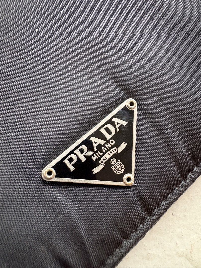 Authentic Prada Tessuto Nylon Continental Flap Long Wallet (Category: Luxury Bags & Wallets) located in Mandaluyong City. Submitted by wear_your_style (Listing ID 1465198556, Image 3). Description: Super steal. Bought this preloved in Japan years ago. Made in Italy. Combination of nylon (outer) and saffiano leather (inner) materials. Snap button closure, snappy pa yan. Well structured pa yan. Black pa. Prada triangle logo wala namang scratches. M