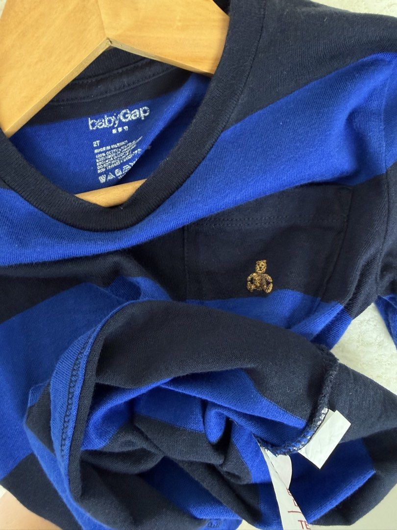 BabyGap Blue Black Striped Bear Tee Size 2T (Category: Babies & Kids Fashion) located in Manila. Submitted by happy_kidsapparel (Listing ID 1465248636, Image 2). Description: BabyGap toddler t-shirt in blue and black stripes. Short sleeves, crew neck, and one chest pocket. Little embroidered bear icon on the pocket. Size 2T on the inner label. 100 percent cotton material. Clean and well maintained..
