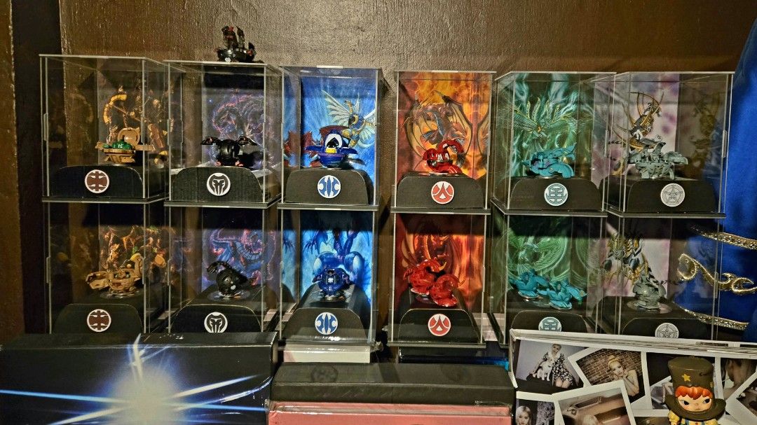 Bakugan Collection with Display Cases All Six Attributes (Category: Action & Battle Toys) located in Rizal. Submitted by silo2191 (Listing ID 1465358363, Image 2). Description: - Complete full set of Bakugan figures across all 6 factions: Subterra, Darkus, Haos, Pyrus, Ventus, and Aquos - Displayed in clear acrylic cases featuring custom art backdrops - Kept clean and well-maintained on shelf display - Ideal and ready-made setup for serious colle